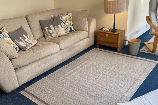 Comfortable counselling room with sofa, lamp, and rug.